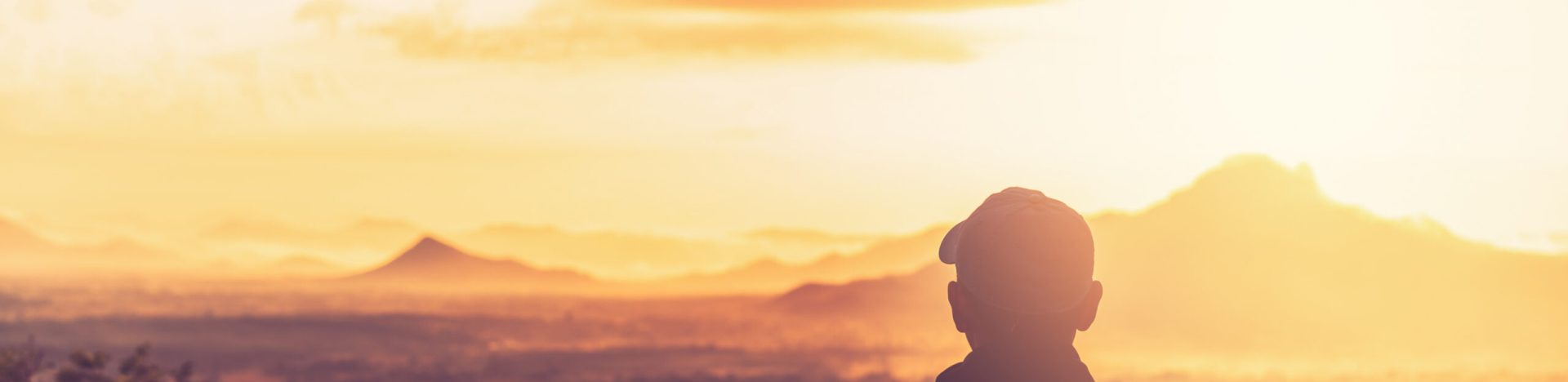 Copy space of backpack man looking view on top of mountain and sunset sky abstract background. Freedom travel adventure and business victory concept. Vintage tone filter effect color style.