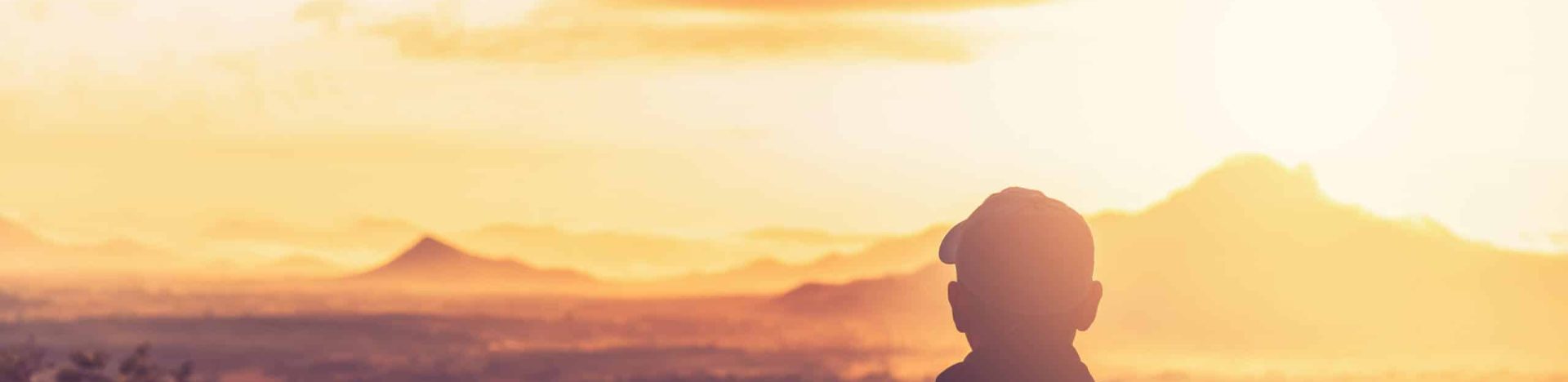 Copy space of backpack man looking view on top of mountain and sunset sky abstract background. Freedom travel adventure and business victory concept. Vintage tone filter effect color style.